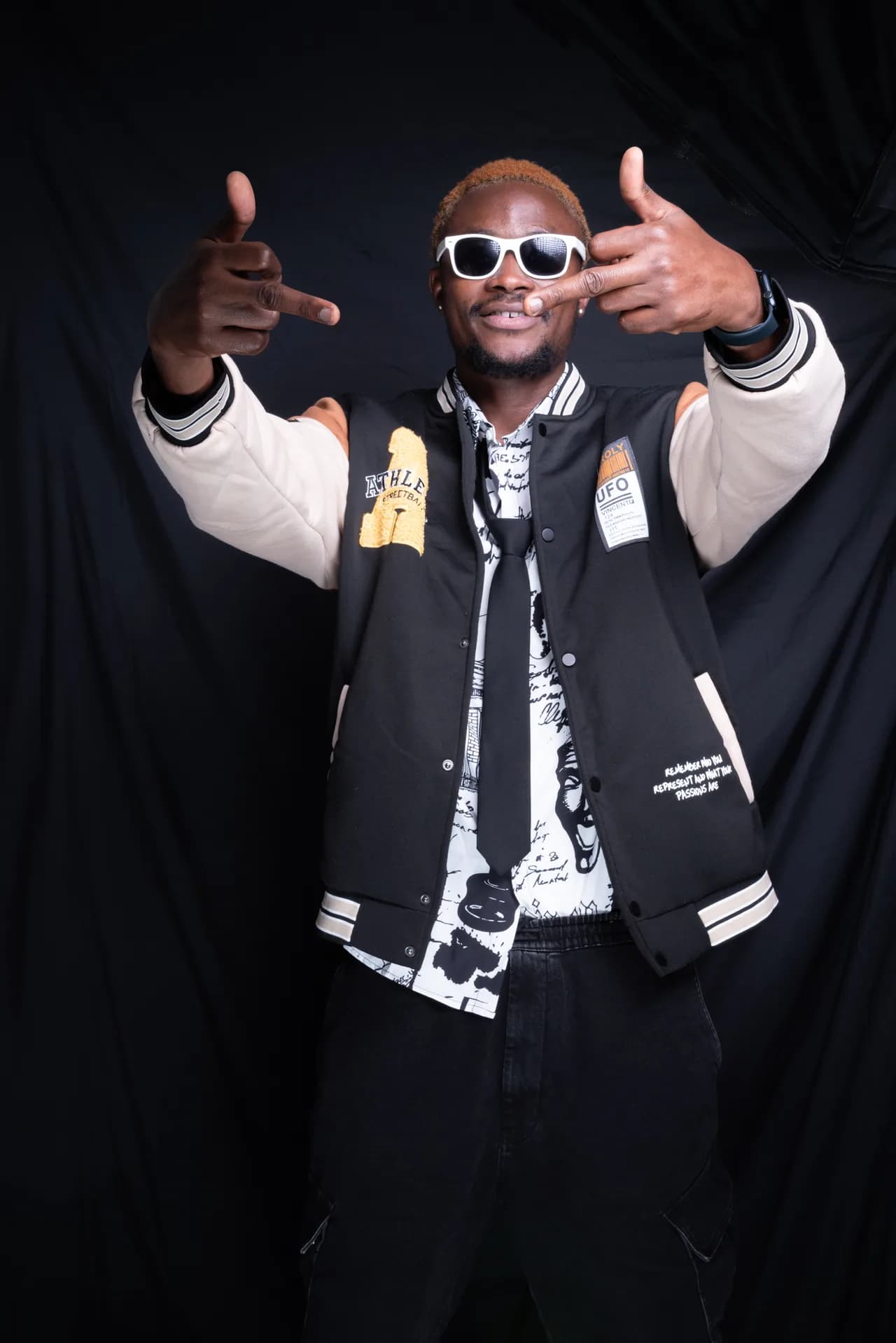 Streetwear-Porträt eines Mannes mit Sonnenbrille und Fingerzeig-Pose